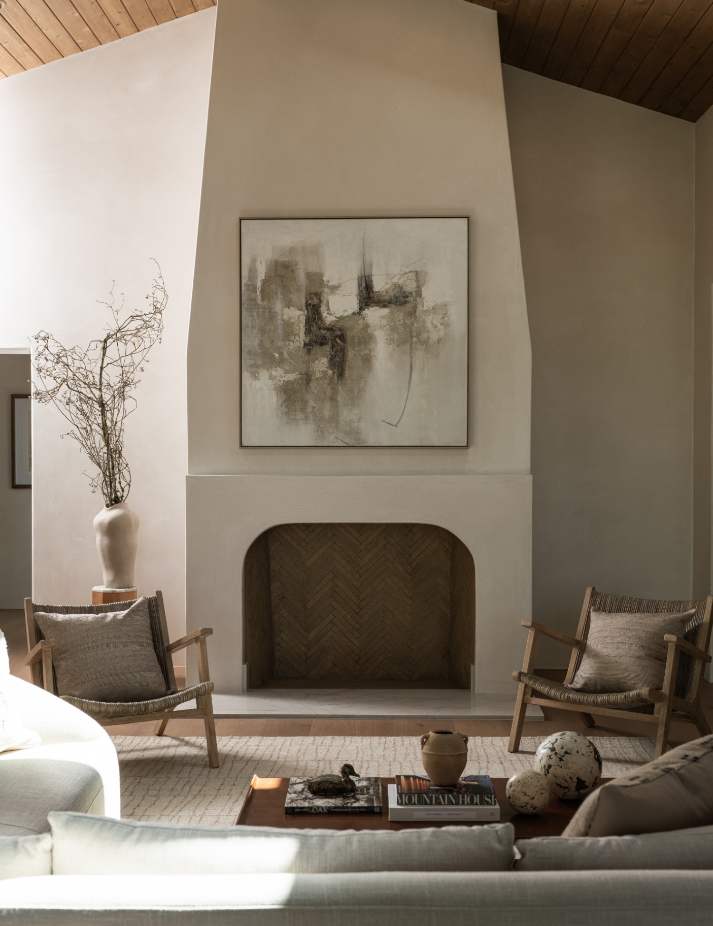 Vaulted living room anchored by fireplace and fine art