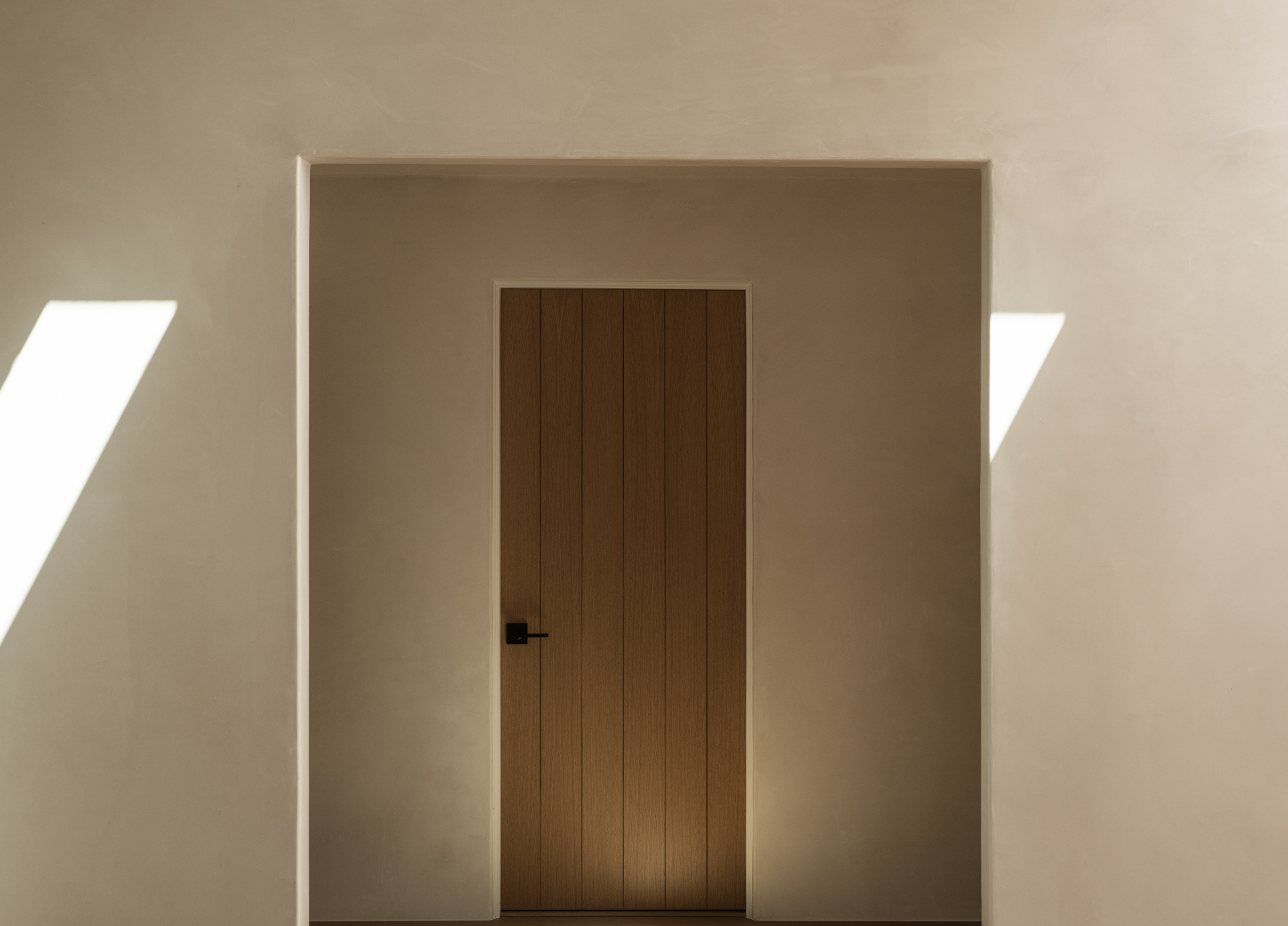 Solid oak door along a sunlit hallway
