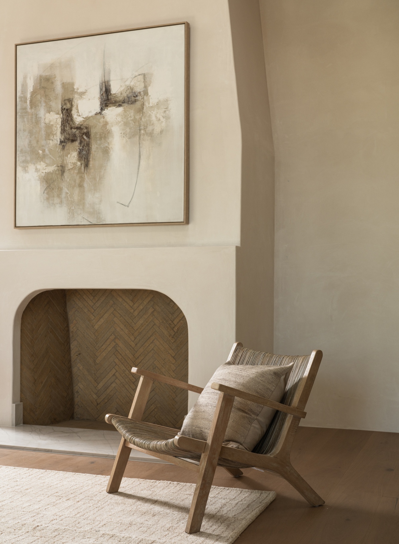 Contemporary art above the herringbone-laid hearth