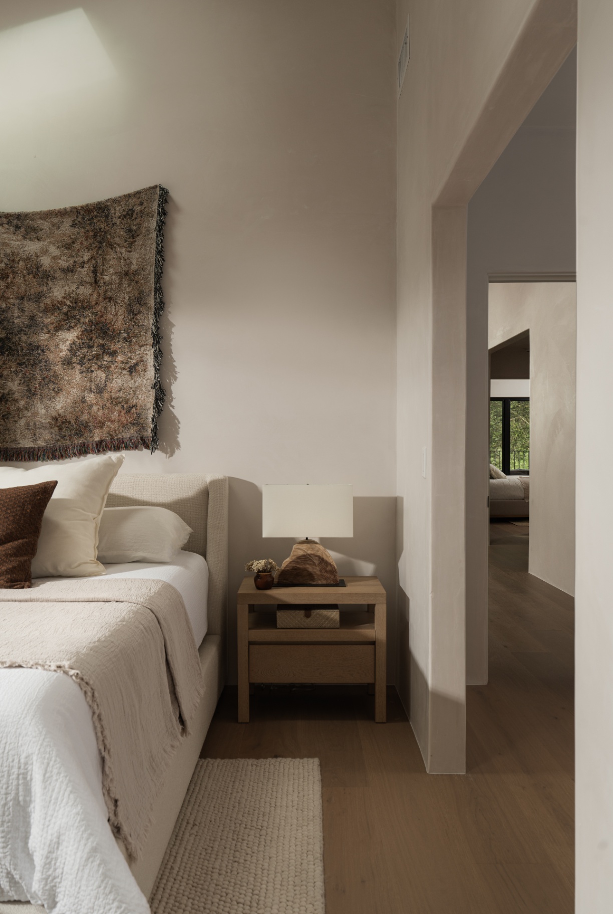 Bedroom layered with woven wall hanging