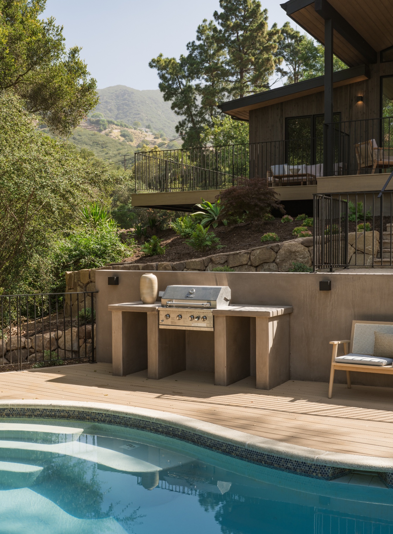 Pool terrace and outdoor grill below the mountains